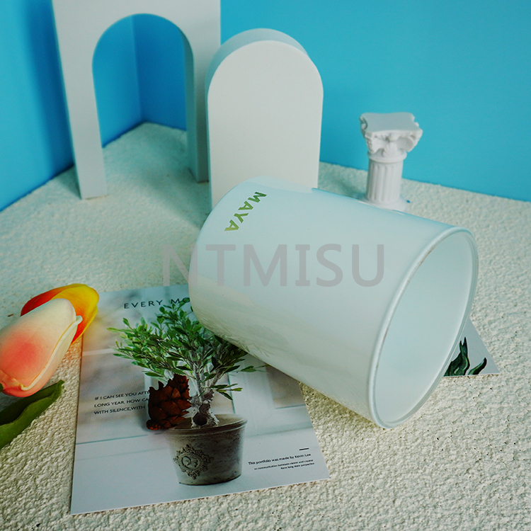 كأس شمعة زجاجي أبيض نقي بمظهر أنيق مع شعار برونزي