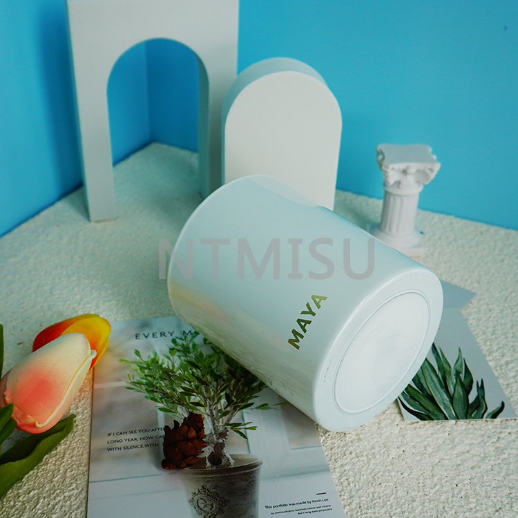 كأس شمعة زجاجي أبيض نقي بمظهر أنيق مع شعار برونزي